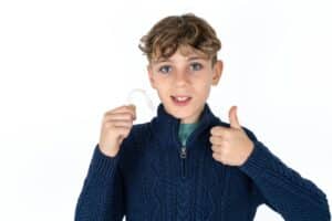 Teen holds Invisalign® aligner in Salem, OR